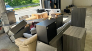 Junk Removal Inc professional loading a sofa onto a truck in Sudbury, MA.