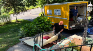 Junk removal crew lifting old furniture in Brookline, MA